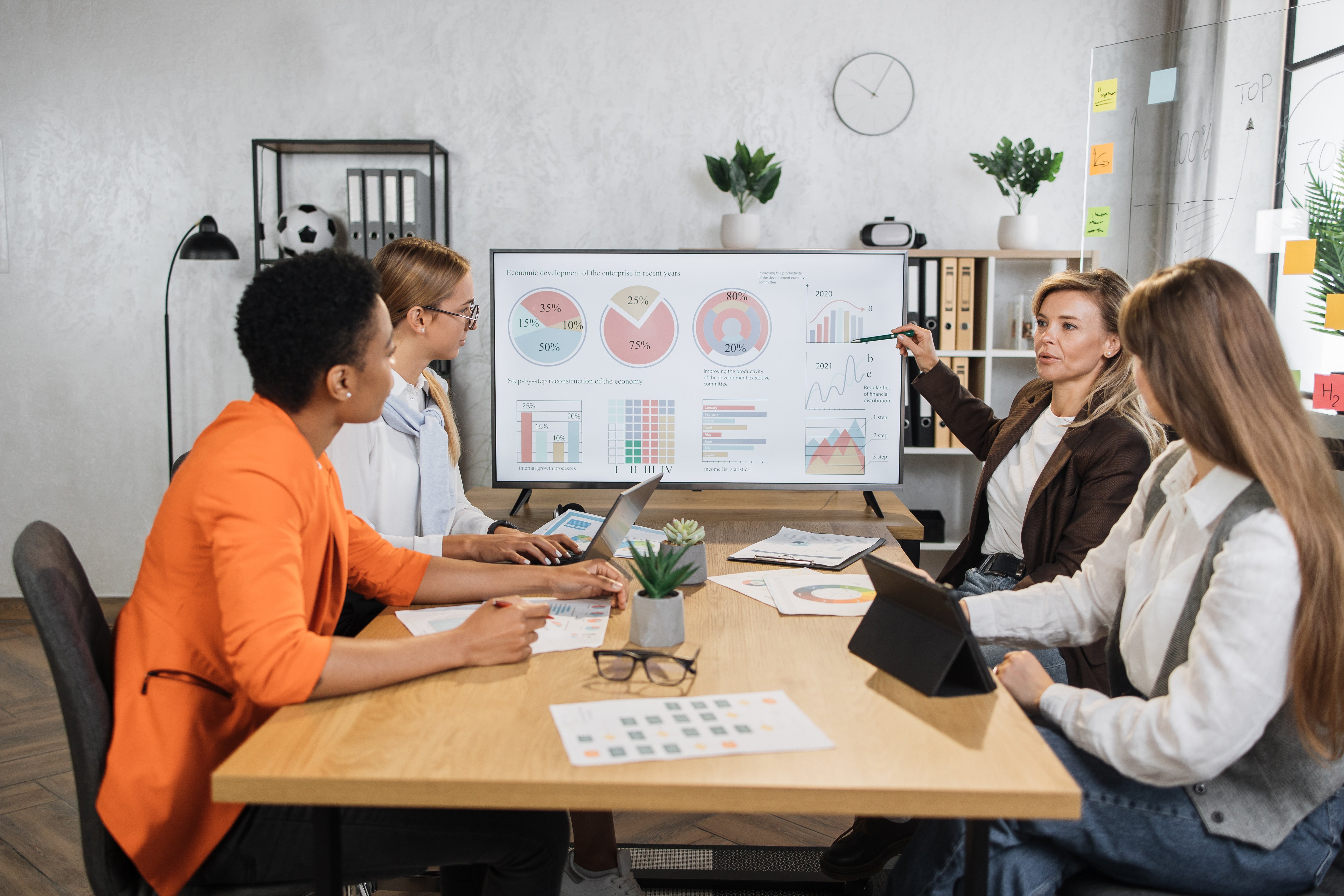 four-female-partners-sitting-at-desk-and-discussin-2023-11-27-05-34-29-utc
